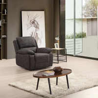 Grey armchair in a modern living room with a coffee table and decorative items.
