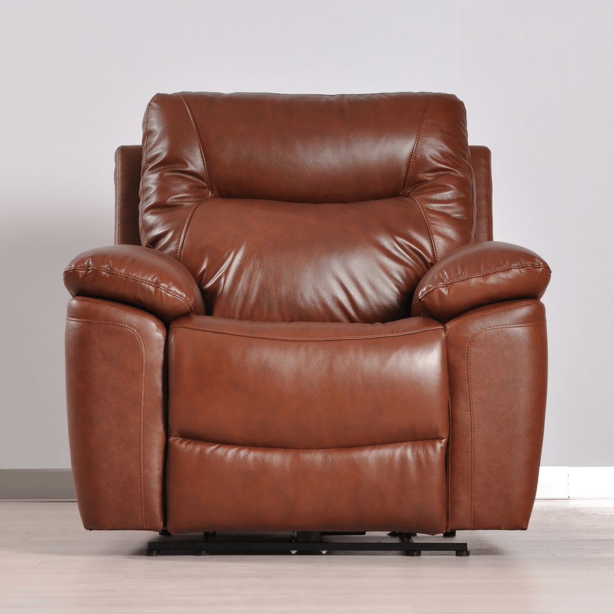 Brown leather recliner chair on a light wooden floor with a neutral background