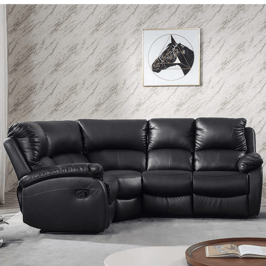 Black leather sectional sofa in a living room with a marble wall and framed picture.