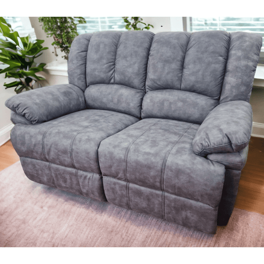 Gray sofa in a living room setting with plants and a window.